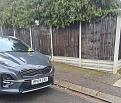 Car parked directly outside a fence.